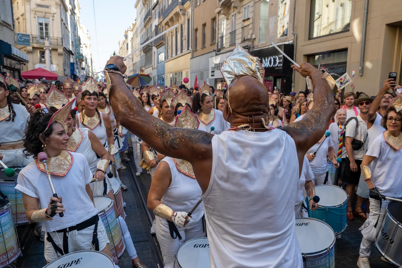 Wide view of the percussion ensemble and crowd filling the street at Marseille Pride